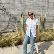 Person standing outdoors with cacti and plants in the background